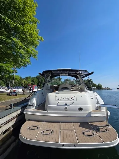 2 Spicy Yacht Photos Pics 2003 Sea Ray 380 Sundancer docked by a serene lakeside under a clear blue sky.