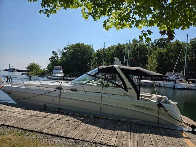 2 Spicy Yacht Photos Pics 2003 Sea Ray 380 Sundancer docked at a marina, surrounded by trees and other boats.