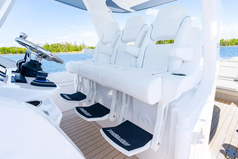  Yacht Photos Pics Luxury seating on 2025 Intrepid 41 Panacea boat, featuring sleek white design and modern controls.