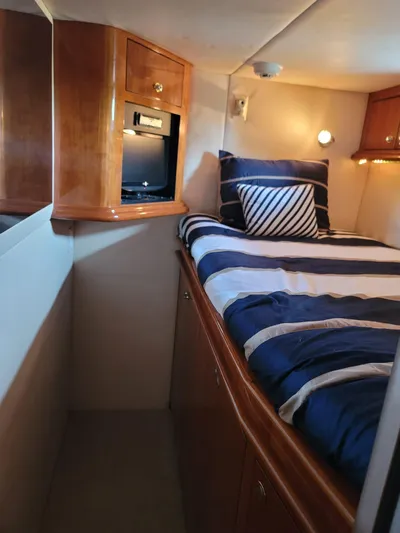  Yacht Photos Pics Cozy cabin interior of 2003 Sea Ray 680 Sun Sport with striped bedding and wooden cabinetry.