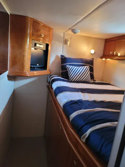  Yacht Photos Pics Cozy cabin interior of 2003 Sea Ray 680 Sun Sport with striped bedding and wooden cabinetry.
