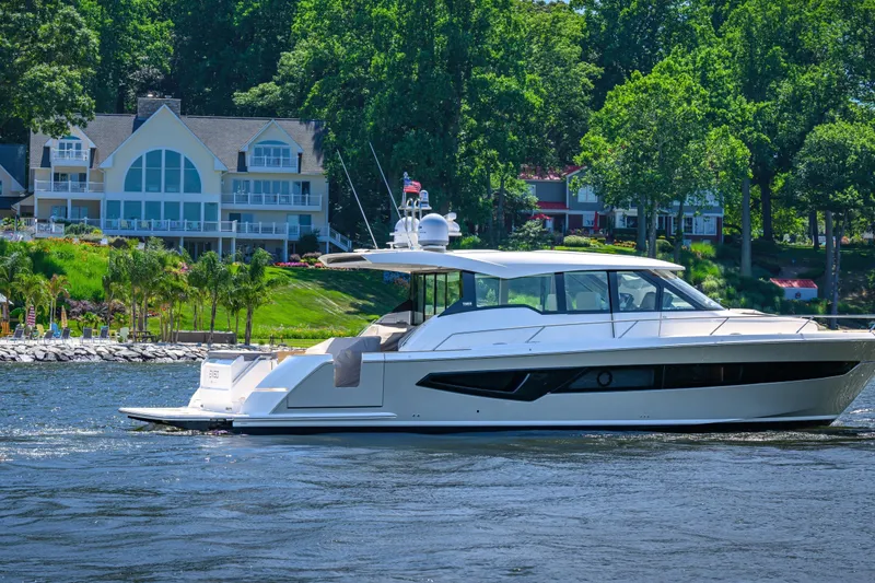 Jack's Boat Yacht Photos Pics 2024 Tiara Yachts EX 60 cruising on a scenic lake near luxury homes.