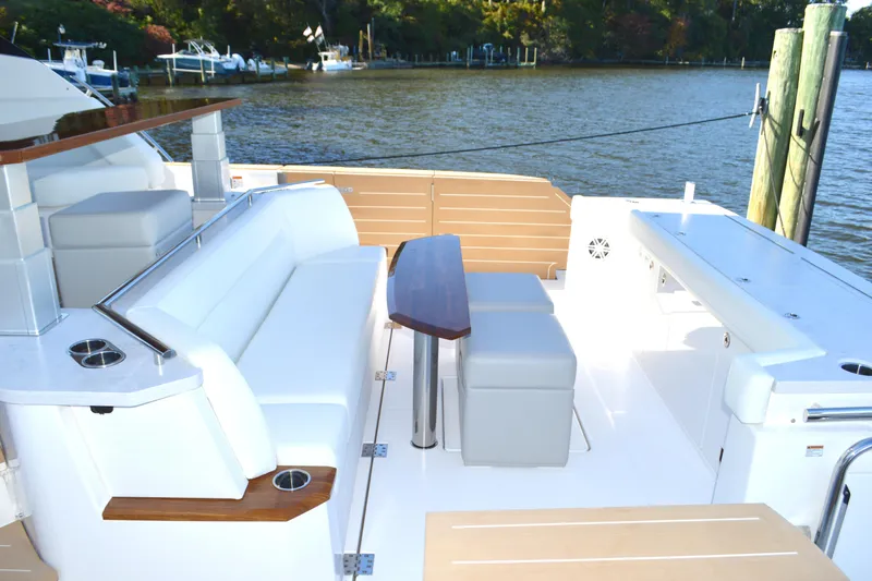 Jack's Boat Yacht Photos Pics Luxurious 2024 Tiara Yachts EX 60 deck with elegant seating and table by the water.