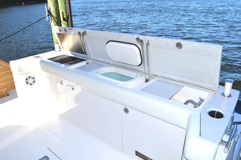 Jack's Boat Yacht Photos Pics Outdoor kitchen on 2024 Tiara Yachts EX 60, featuring sink and storage, by the water.