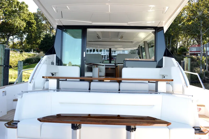 Jack's Boat Yacht Photos Pics 2024 Tiara Yachts EX 60 luxury yacht interior with seating and table, docked outdoors.