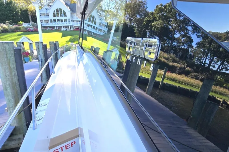 Jack's Boat Yacht Photos Pics 2024 Tiara Yachts EX 60 docked near a scenic waterfront property.