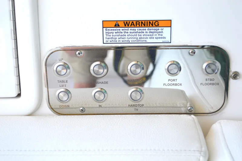 Jack's Boat Yacht Photos Pics Control panel on 2024 Tiara Yachts EX 60 with various function buttons and warning label.