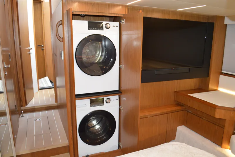 Jack's Boat Yacht Photos Pics 2024 Tiara Yachts EX 60 interior with washer-dryer and TV in wooden cabinetry.