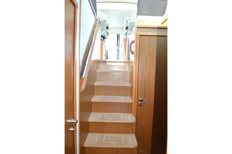 Jack's Boat Yacht Photos Pics Staircase inside 2024 Tiara Yachts EX 60, featuring sleek wooden design and modern finish.