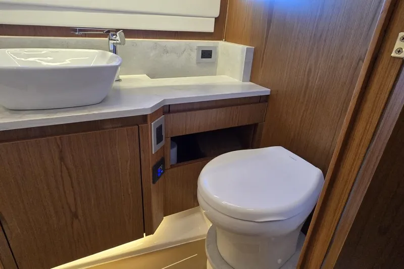 Jack's Boat Yacht Photos Pics Luxurious bathroom in 2024 Tiara Yachts EX 60, featuring modern sink and toilet.