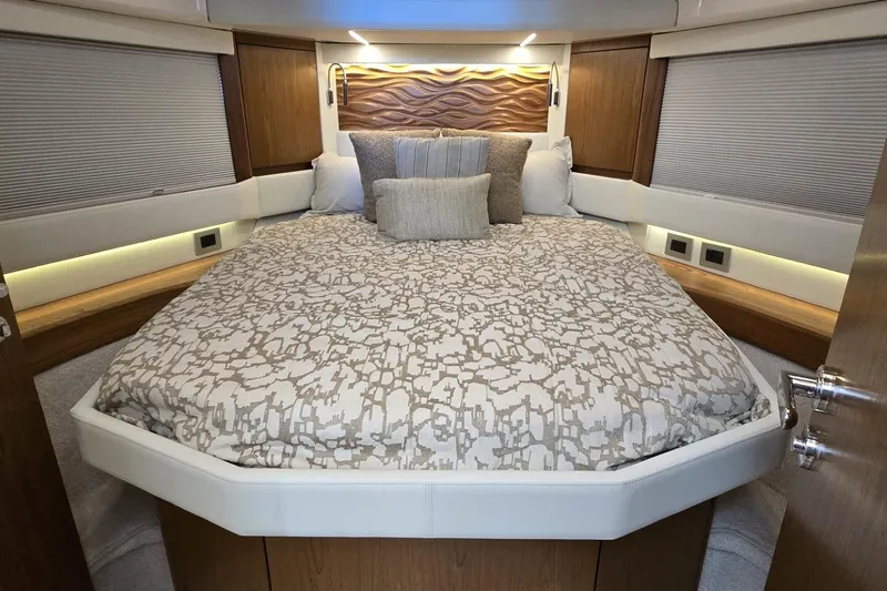 Jack's Boat Yacht Photos Pics Luxurious bedroom interior of 2024 Tiara Yachts EX 60, featuring elegant bedding and wood accents.
