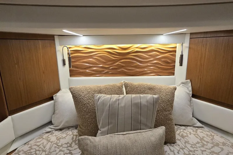 Jack's Boat Yacht Photos Pics Luxurious 2024 Tiara Yachts EX 60 cabin interior with elegant wood paneling and plush pillows.