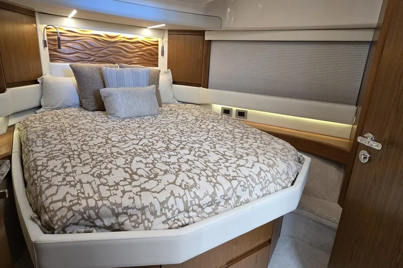 Jack's Boat Yacht Photos Pics Luxurious bedroom interior of 2024 Tiara Yachts EX 60 with elegant bedding and wood accents.