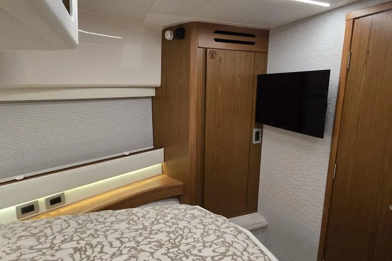 Jack's Boat Yacht Photos Pics 2024 Tiara Yachts EX 60 interior cabin with wood accents and mounted TV.