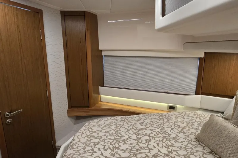 Jack's Boat Yacht Photos Pics 2024 Tiara Yachts EX 60 interior cabin with modern wood accents and cozy bedding.