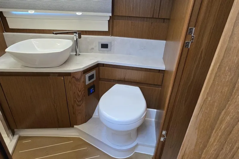 Jack's Boat Yacht Photos Pics Luxurious bathroom in 2024 Tiara Yachts EX 60 with modern sink and toilet.