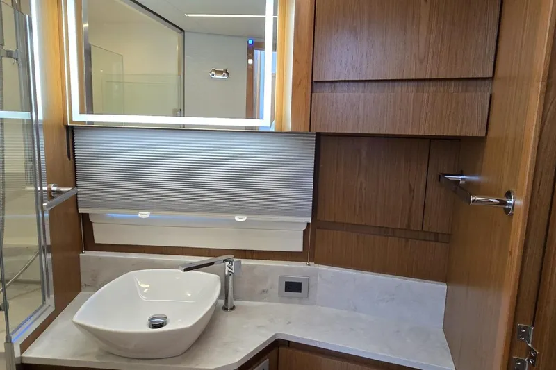 Jack's Boat Yacht Photos Pics Luxurious bathroom interior of 2024 Tiara Yachts EX 60 with modern sink and wood cabinetry.