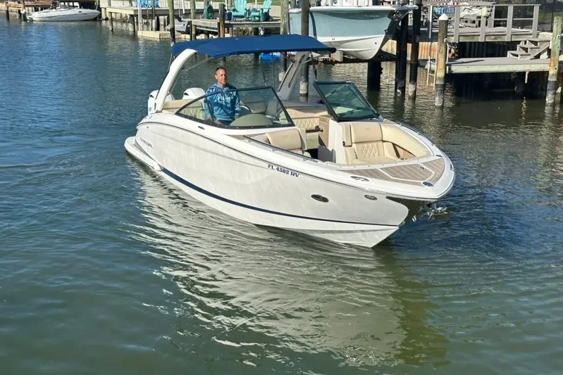 Yacht Photos Pics 2019 Regal 29 OBX boat cruising in a marina with a blue canopy.