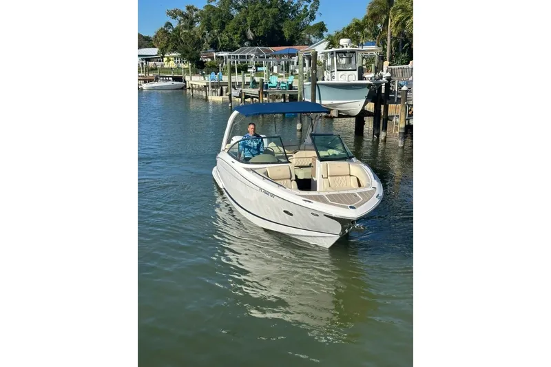  Yacht Photos Pics 2019 Regal 29 OBX boat cruising on a sunny day near a dock.
