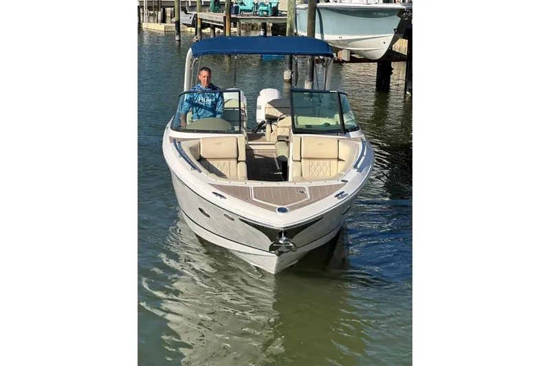  Yacht Photos Pics 2019 Regal 29 OBX boat with blue canopy on calm water.