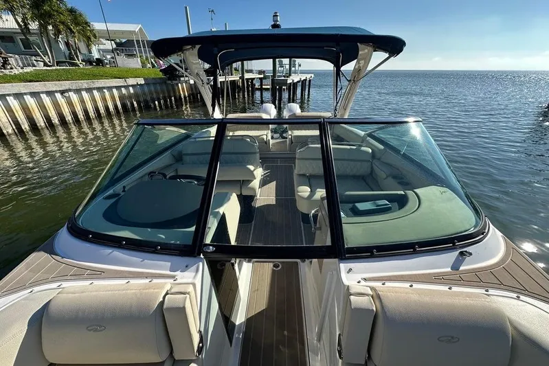  Yacht Photos Pics 2019 Regal 29 OBX boat docked by the water, showcasing spacious seating and sleek design.