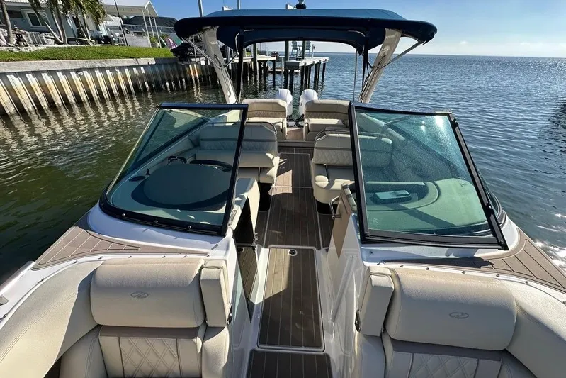  Yacht Photos Pics 2019 Regal 29 OBX boat with spacious seating, docked by the water.