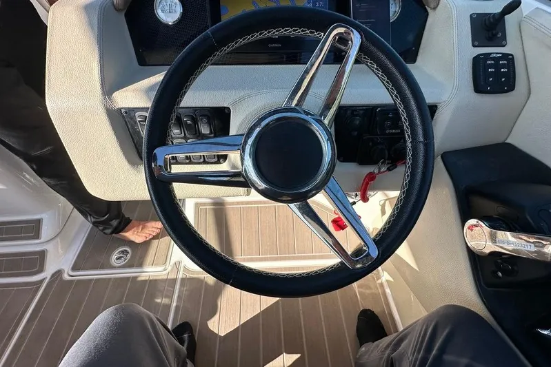  Yacht Photos Pics Steering wheel of a 2019 Regal 29 OBX boat, featuring modern controls and dashboard.