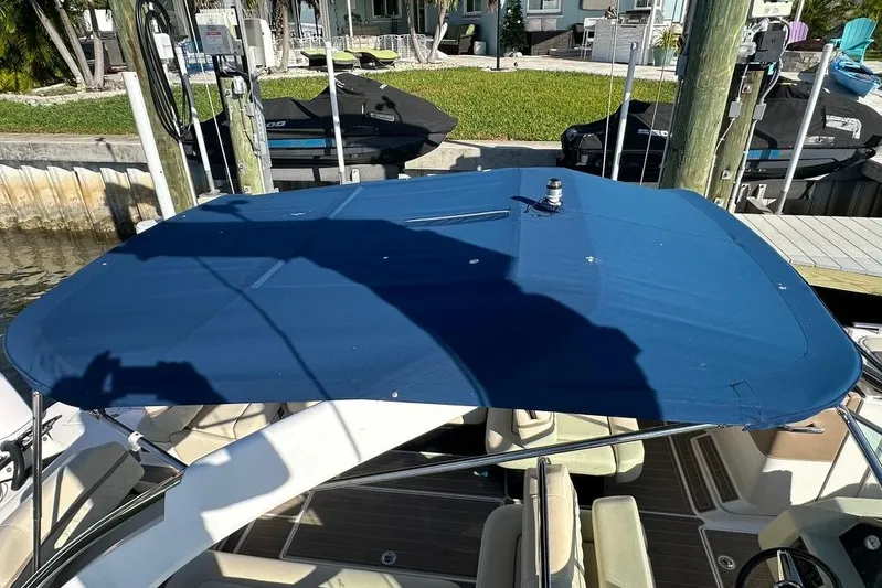  Yacht Photos Pics 2019 Regal 29 OBX boat with blue canopy docked near jet skis.