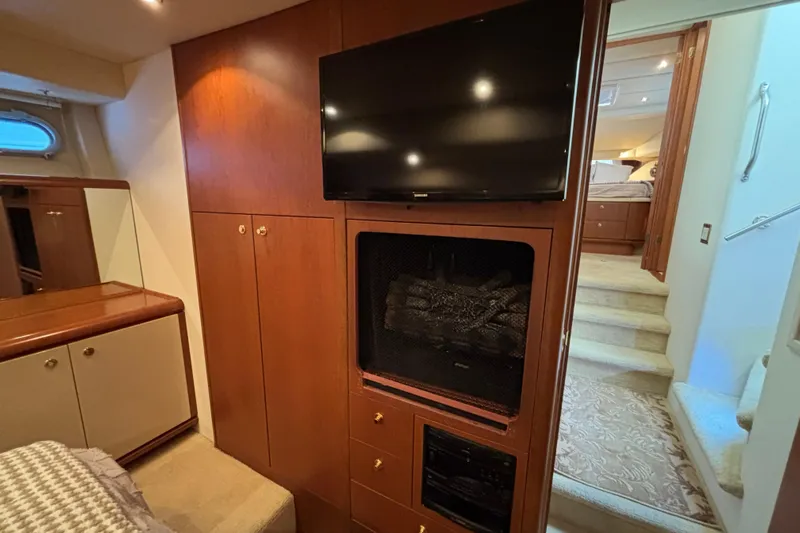Tahoe Yacht Photos Pics Luxurious 1996 Queenship yacht interior with TV, fireplace, and elegant wood cabinetry.
