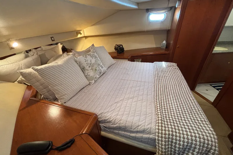 Tahoe Yacht Photos Pics Luxurious 1996 Queenship yacht bedroom with cozy bedding and elegant wood finishes.