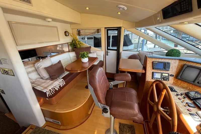 Tahoe Yacht Photos Pics Luxurious 1996 Queenship yacht interior with plush seating, wooden helm, and modern navigation equipment.