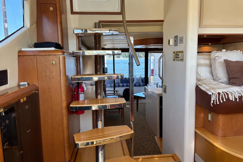 Tahoe Yacht Photos Pics Interior of a 1996 Queenship yacht with wooden stairs and cozy seating area.
