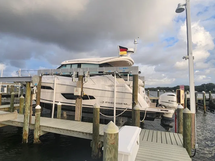 Dilligaf Yacht Photos Pics 2020 Regal 38 XO yacht docked at marina under cloudy sky.