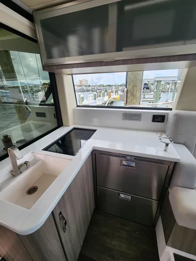 Dilligaf Yacht Photos Pics 2020 Regal 38 XO yacht kitchen with modern appliances and waterfront view.