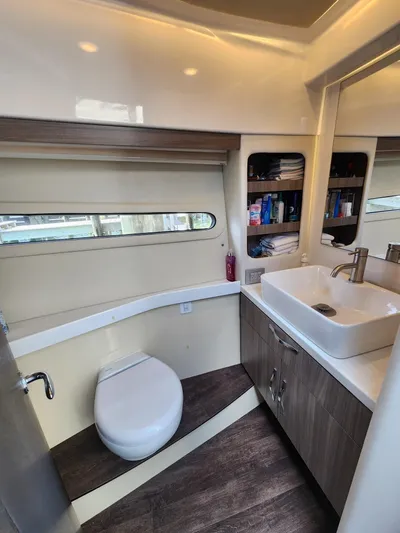 Dilligaf Yacht Photos Pics 2020 Regal 38 XO yacht bathroom with modern sink, toilet, and storage shelves.