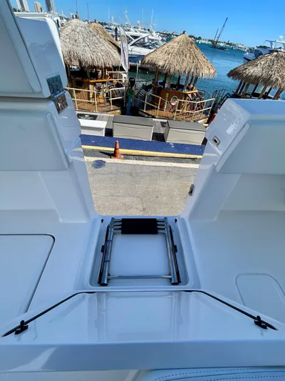 Deeper Yacht Photos Pics 2022 Invincible 39' Open Fisherman boat with dockside view and tiki huts in the background.