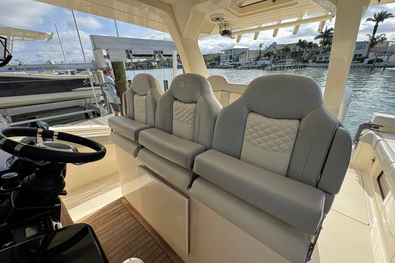  Yacht Photos Pics 2024 Scout 425 LXF boat interior with luxurious seating and steering wheel, dockside view.