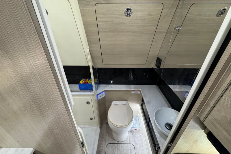  Yacht Photos Pics 2024 Scout 425 LXF boat bathroom with modern fixtures and wood paneling.