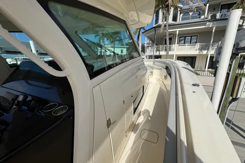  Yacht Photos Pics 2024 Scout 425 LXF boat docked near waterfront homes.