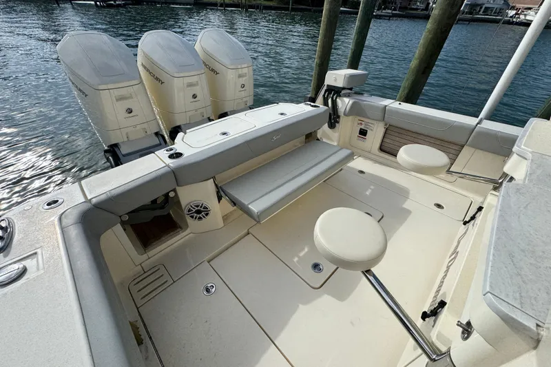  Yacht Photos Pics 2024 Scout 425 LXF boat interior with triple Mercury engines, seating, and water view.