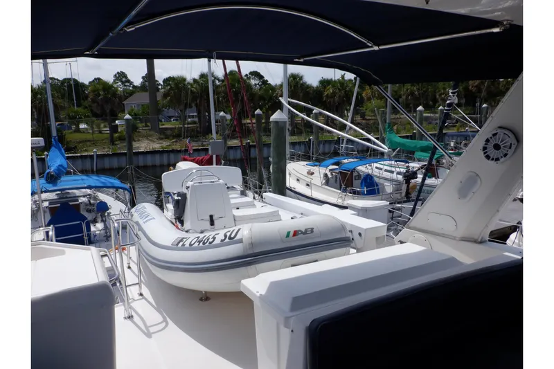 Epic Yacht Photos Pics 1998 Bayliner 4788 Pilot House Motoryacht with inflatable boat on deck, docked at marina.