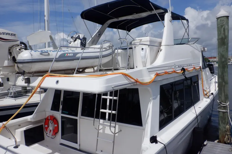 Epic Yacht Photos Pics 1998 Bayliner 4788 Pilot House Motoryacht docked with inflatable boat on top.