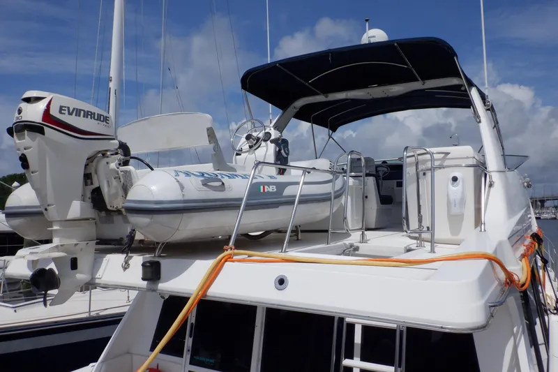 Epic Yacht Photos Pics 1998 Bayliner 4788 Pilot House Motoryacht with Evinrude motor and inflatable boat on deck.