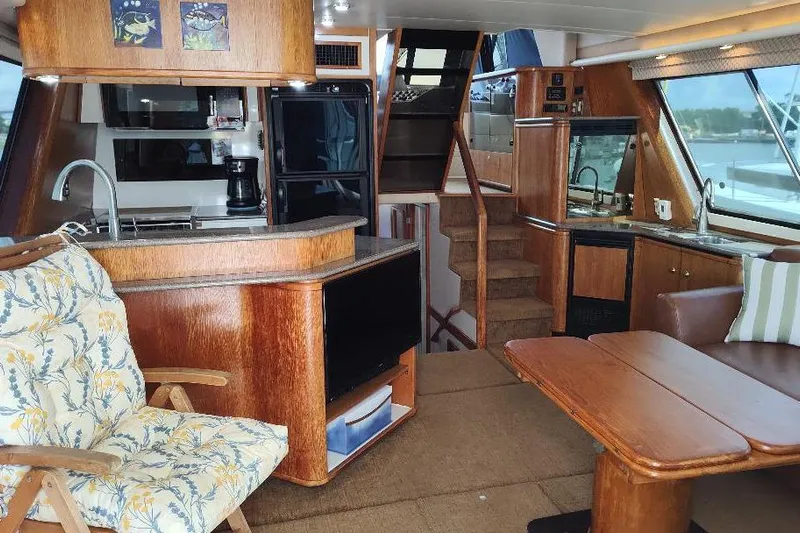 Epic Yacht Photos Pics Interior of 1998 Bayliner 4788 Pilot House Motoryacht with wood finishes and cozy seating.
