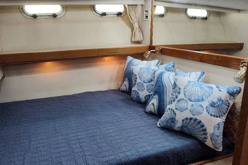 Epic Yacht Photos Pics Cozy bedroom in 1998 Bayliner 4788 Pilot House Motoryacht with nautical-themed pillows.
