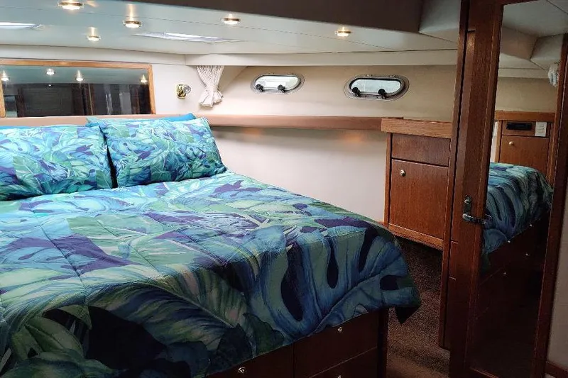 Epic Yacht Photos Pics Luxurious bedroom interior of 1998 Bayliner 4788 Pilot House Motoryacht with vibrant bedding.