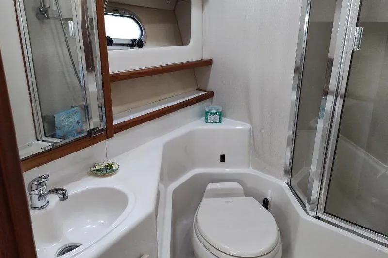 Epic Yacht Photos Pics Bathroom interior of 1998 Bayliner 4788 Pilot House Motoryacht, featuring sink, toilet, and shower.