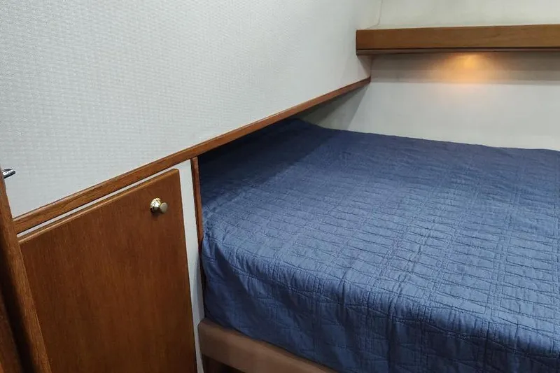 Epic Yacht Photos Pics Cozy cabin interior of 1998 Bayliner 4788 Pilot House Motoryacht with blue bedding.