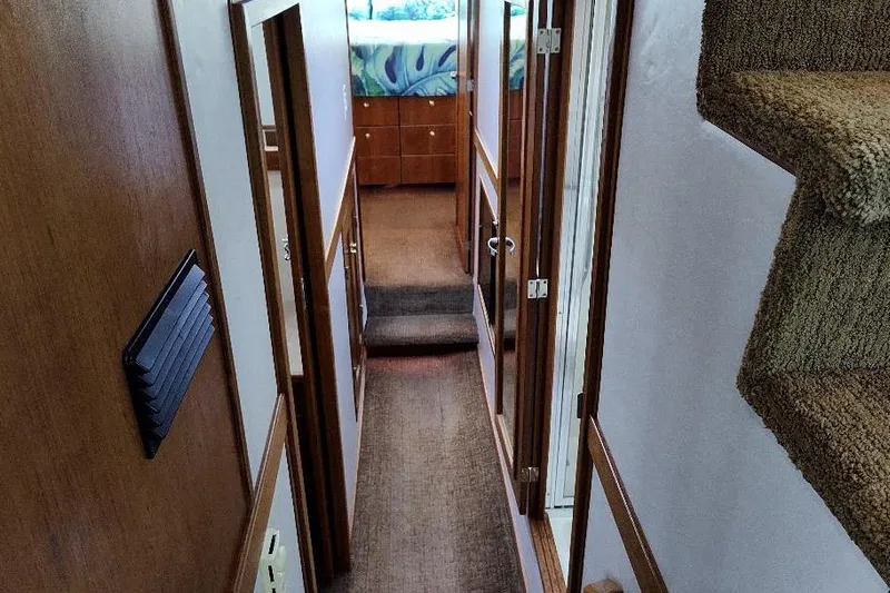 Epic Yacht Photos Pics Interior hallway of 1998 Bayliner 4788 Pilot House Motoryacht, featuring carpeted stairs and wooden paneling.