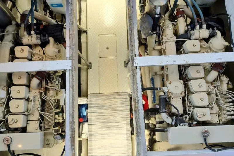 Epic Yacht Photos Pics Engine room of 1998 Bayliner 4788 Pilot House Motoryacht, showcasing dual engines and mechanical components.
